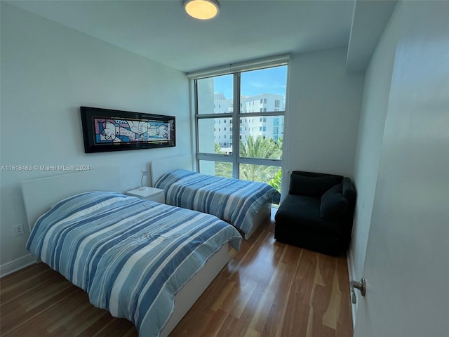 bedroom with hardwood / wood-style flooring and a wall of windows