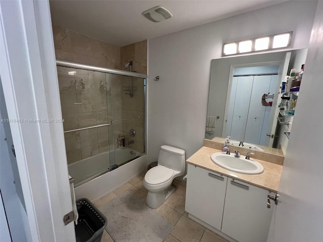 full bathroom featuring tile patterned flooring, vanity, enclosed tub / shower combo, and toilet