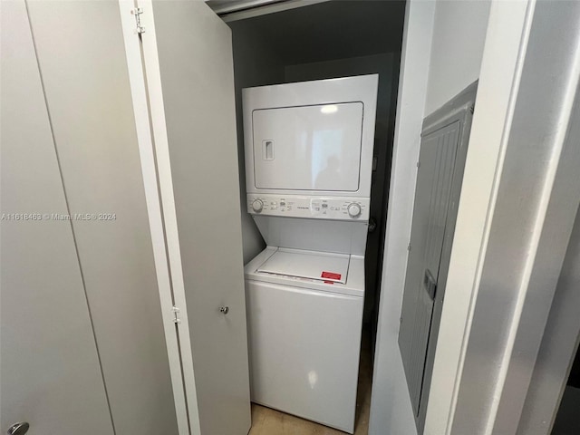 laundry room featuring stacked washer / dryer and light hardwood / wood-style flooring