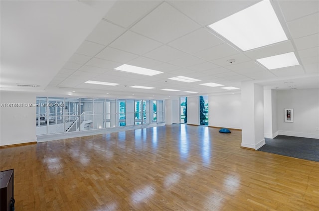 empty room with a paneled ceiling and hardwood / wood-style floors