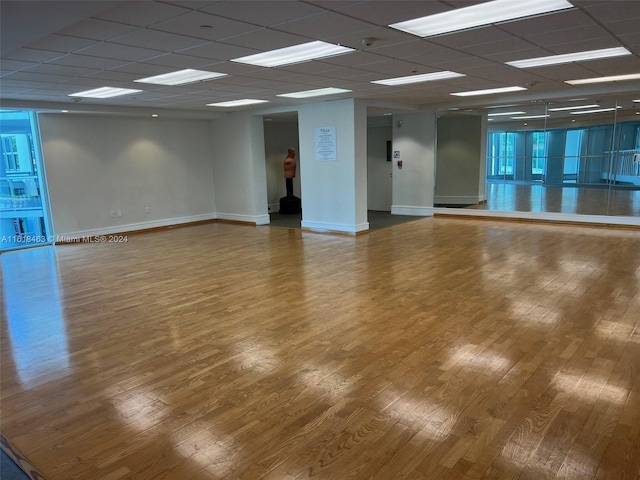 empty room featuring wood-type flooring and a drop ceiling