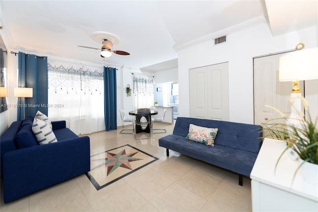 tiled living room featuring ceiling fan and crown molding