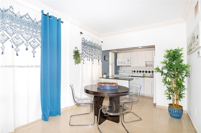 tiled dining room featuring ornamental molding