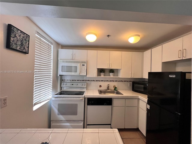 kitchen with sink, black appliances, white cabinets, and backsplash