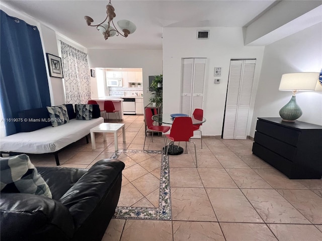 tiled living room featuring a notable chandelier