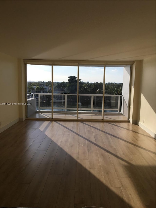 unfurnished room with wood-type flooring and expansive windows