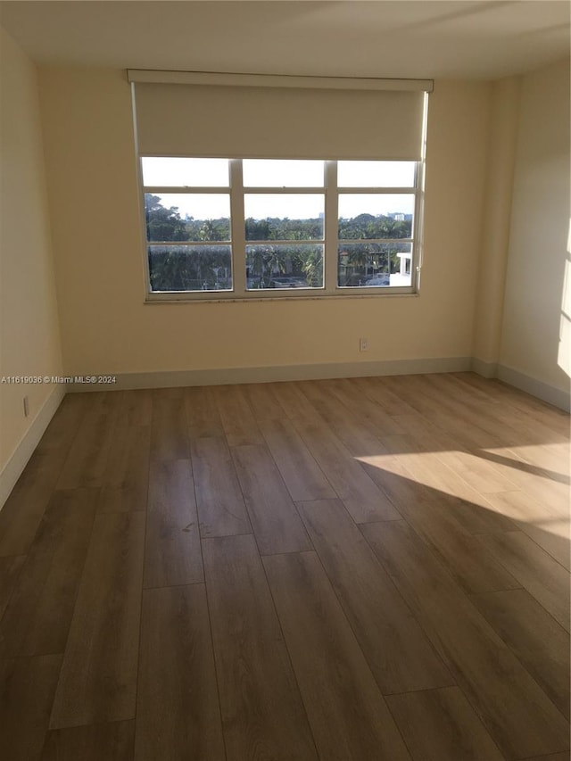 unfurnished room with hardwood / wood-style floors and a healthy amount of sunlight