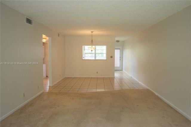 carpeted empty room featuring a textured ceiling