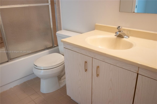 full bathroom with tile patterned floors, toilet, vanity, and combined bath / shower with glass door