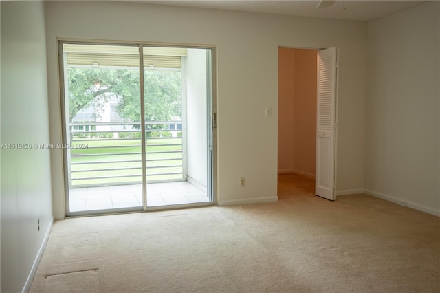 carpeted spare room featuring ceiling fan