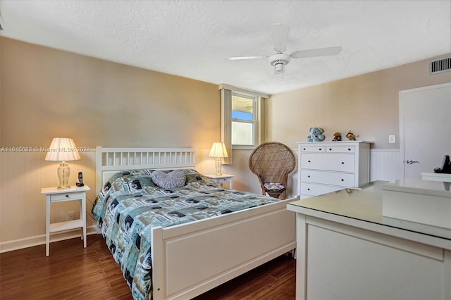 bedroom featuring ceiling fan, a textured ceiling, and dark hardwood / wood-style flooring