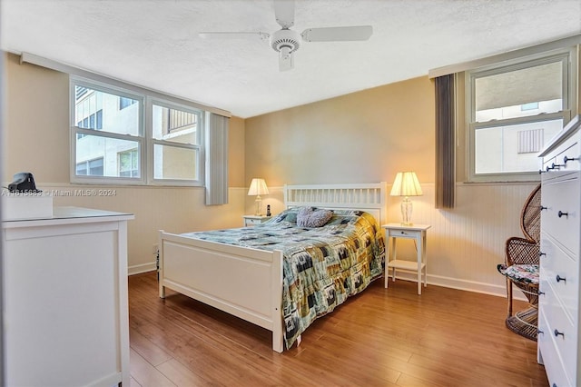 bedroom featuring hardwood / wood-style flooring, a textured ceiling, and ceiling fan