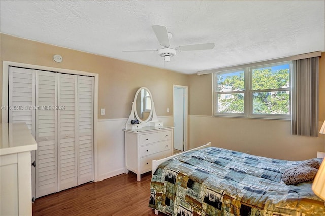 bedroom featuring a closet, a textured ceiling, ceiling fan, and dark hardwood / wood-style floors