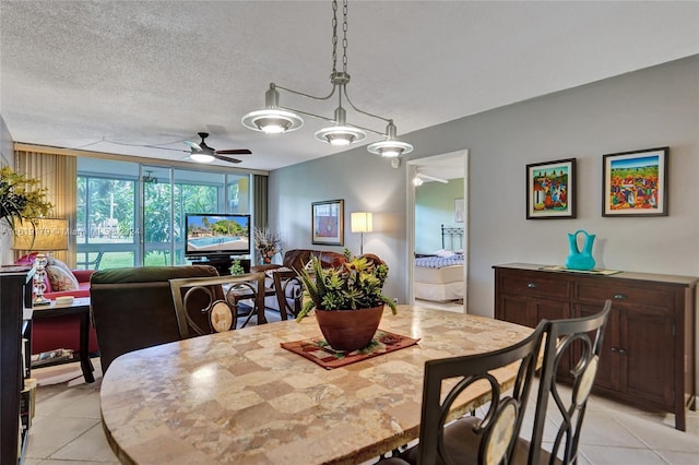 dining space featuring a textured ceiling, ceiling fan with notable chandelier, and light tile patterned floors