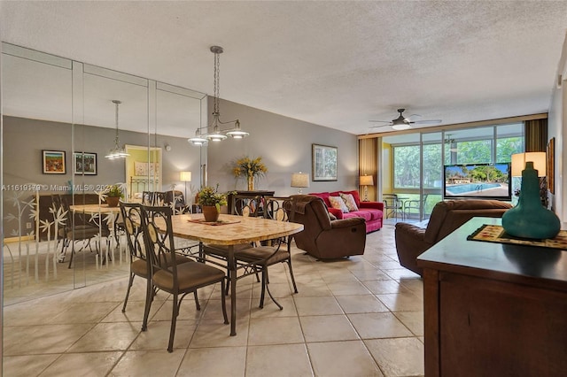 tiled dining space with ceiling fan with notable chandelier and a textured ceiling