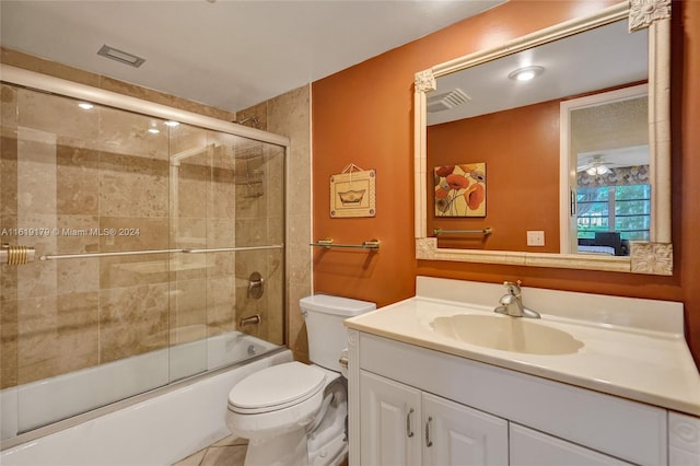 full bathroom featuring tile patterned floors, vanity, bath / shower combo with glass door, and toilet