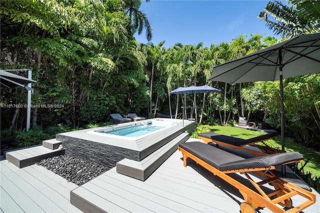 exterior space with an outdoor hot tub and a deck