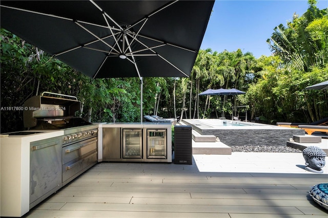 view of patio with exterior kitchen and a pool side deck