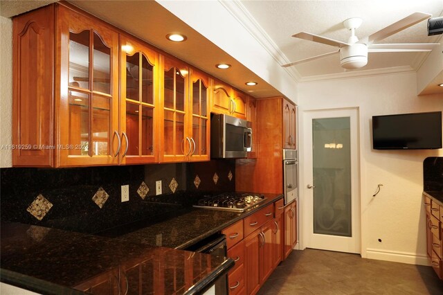 kitchen with dark stone countertops, ceiling fan, appliances with stainless steel finishes, dark tile patterned flooring, and decorative backsplash