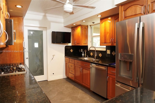 kitchen with sink, decorative backsplash, ornamental molding, ceiling fan, and stainless steel appliances