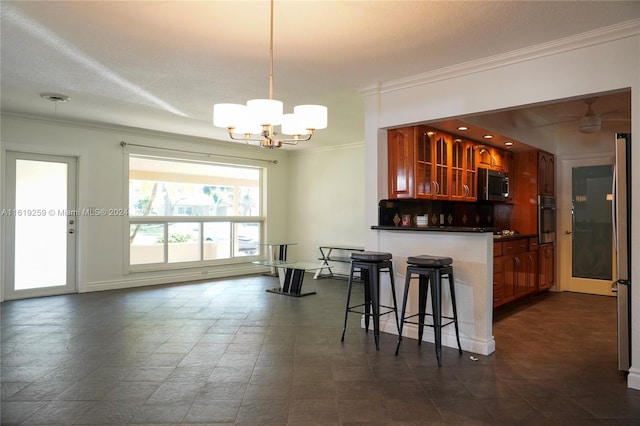 kitchen featuring pendant lighting, a kitchen breakfast bar, stainless steel oven, kitchen peninsula, and crown molding