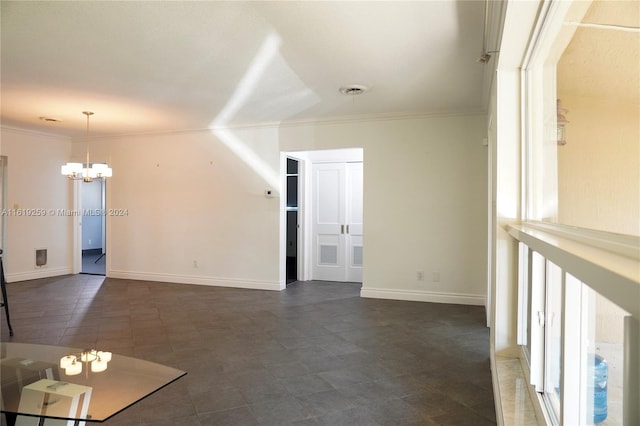 unfurnished room featuring ornamental molding and a chandelier