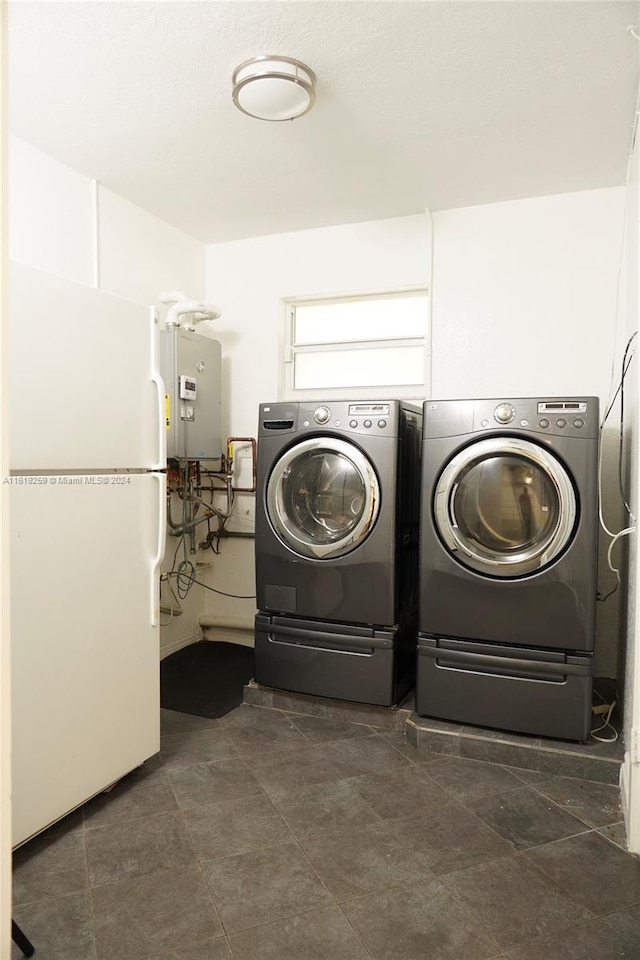 laundry room with separate washer and dryer and water heater