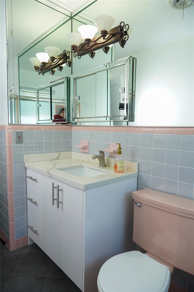 bathroom with tile patterned floors, toilet, tile walls, and vanity