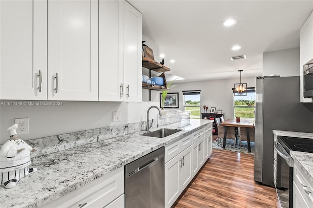 kitchen featuring stainless steel appliances, white cabinets, hardwood / wood-style floors, sink, and light stone counters