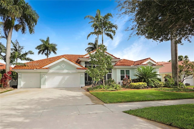 mediterranean / spanish-style home with a garage and a front lawn