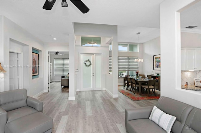 entrance foyer featuring ceiling fan, ornamental molding, and light hardwood / wood-style floors