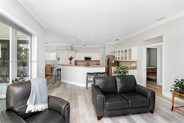 living room with light wood-type flooring and ornamental molding