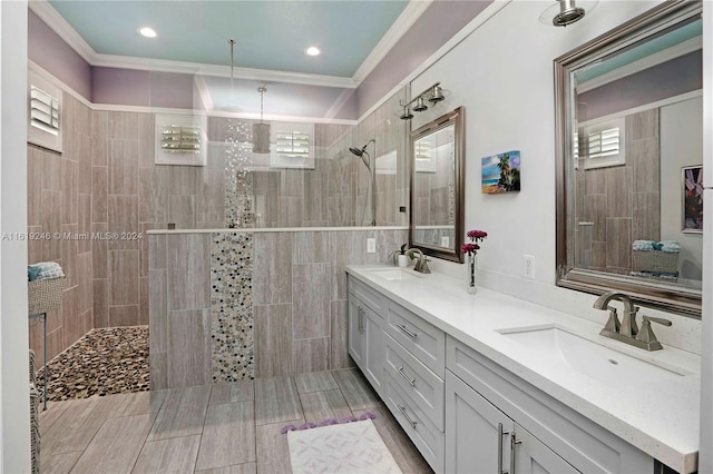 bathroom featuring crown molding, vanity, and tiled shower