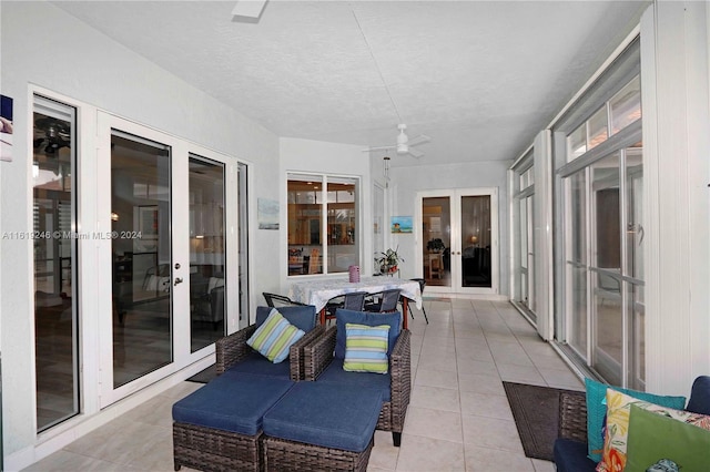 sunroom featuring ceiling fan and french doors