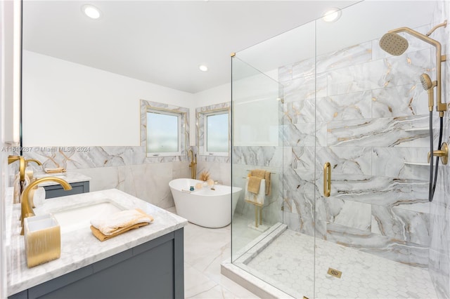 bathroom featuring independent shower and bath, vanity, and tile walls