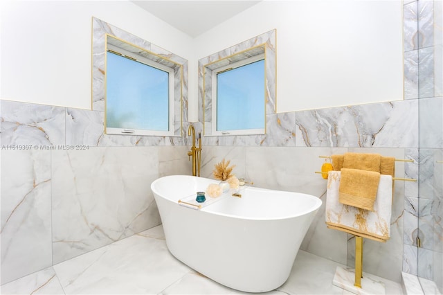 bathroom with tile walls and a bathtub