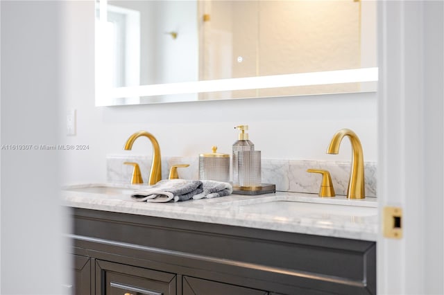 bar featuring dark brown cabinetry, sink, and light stone counters