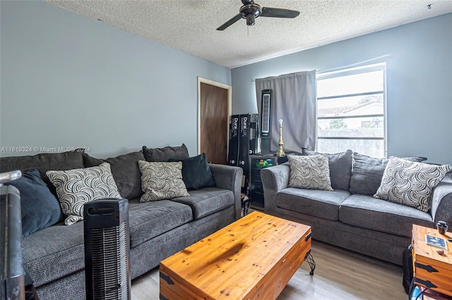 living room featuring ceiling fan, hardwood / wood-style floors, and a textured ceiling