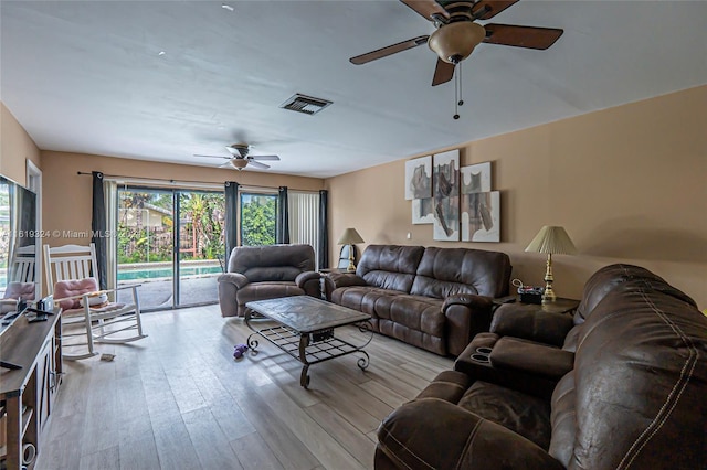 living room featuring light hardwood / wood-style flooring and ceiling fan