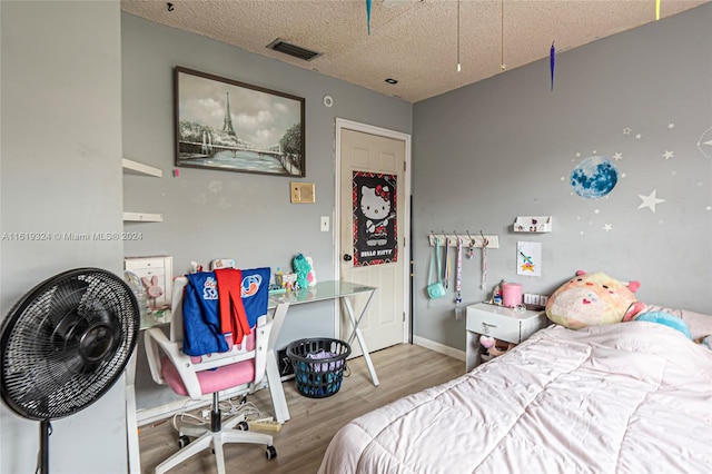 bedroom with a textured ceiling and light wood-type flooring