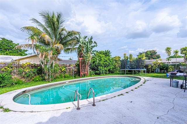 view of pool featuring a trampoline and a patio area