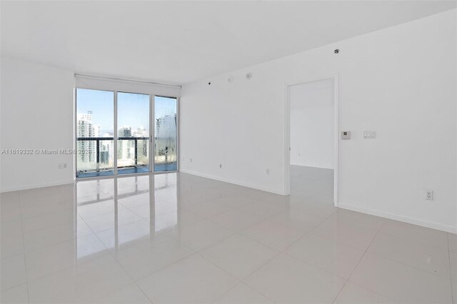 unfurnished room featuring light tile patterned flooring and expansive windows