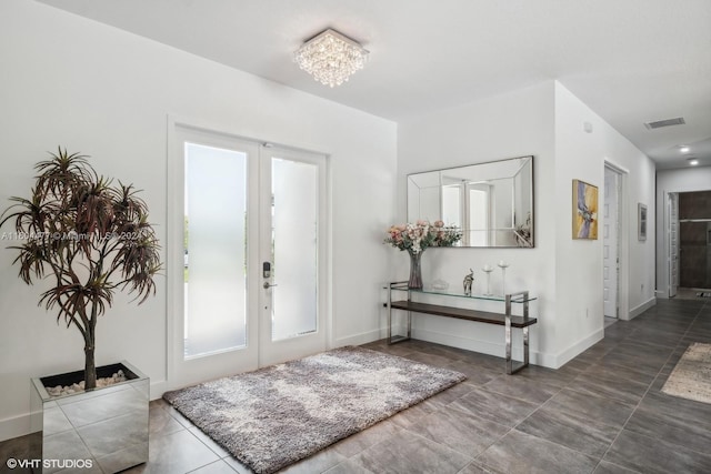 foyer with french doors and a notable chandelier