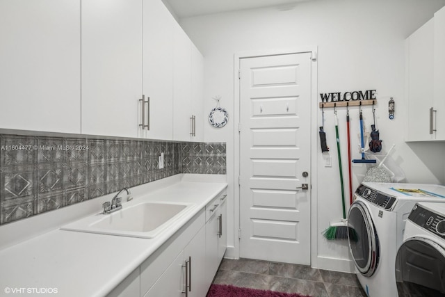 laundry room featuring washing machine and clothes dryer, sink, and cabinets