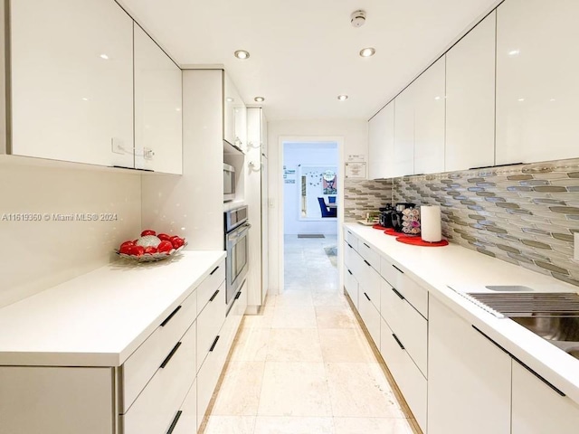 kitchen with white cabinets, tasteful backsplash, and stainless steel oven