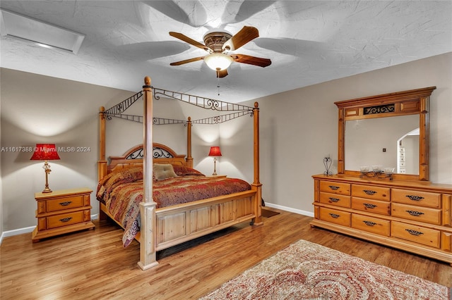 bedroom featuring light wood-type flooring, a textured ceiling, and ceiling fan