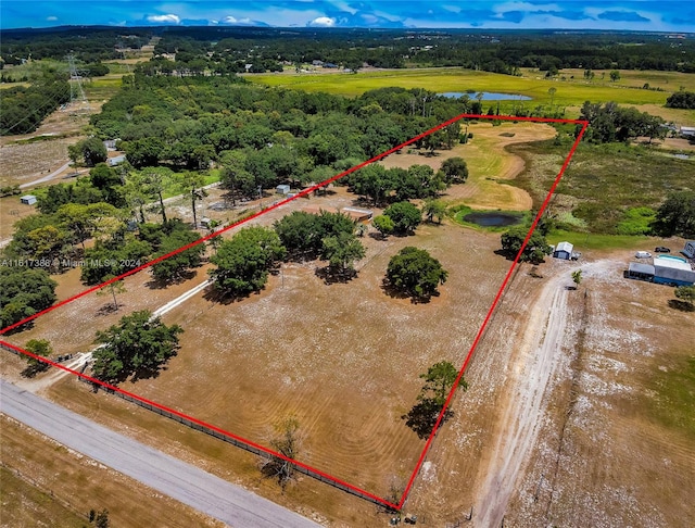 birds eye view of property featuring a water view and a rural view