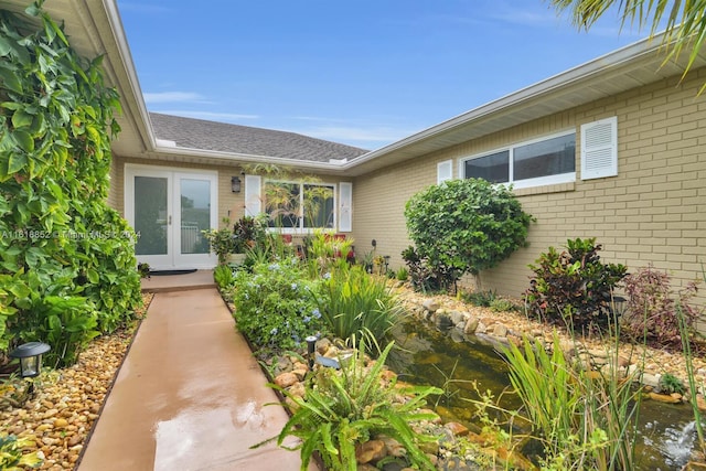 doorway to property featuring brick siding and french doors