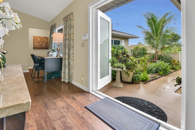 interior space featuring a chandelier, vaulted ceiling, baseboards, and wood finished floors