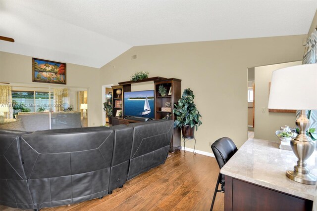 living room with vaulted ceiling and hardwood / wood-style floors